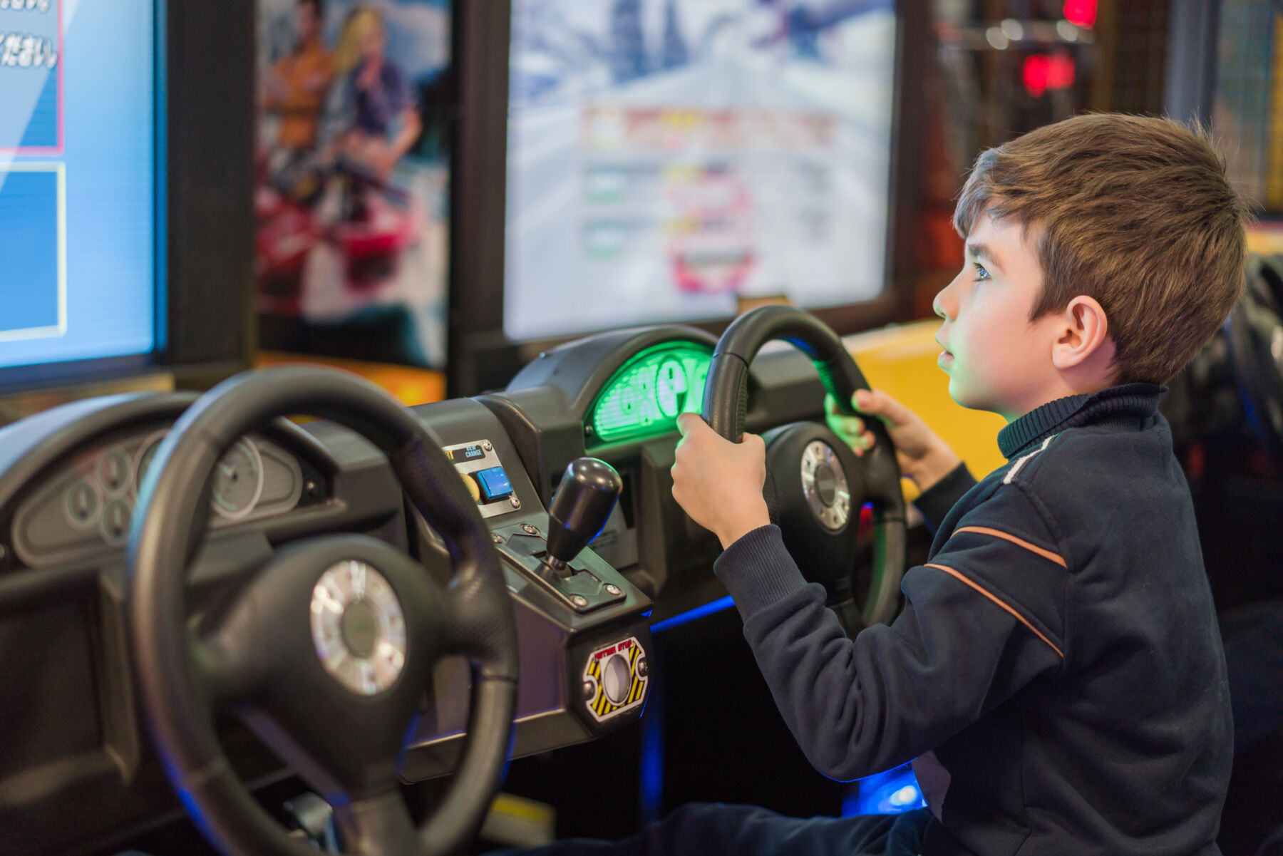 Kid playing a racing arcade game