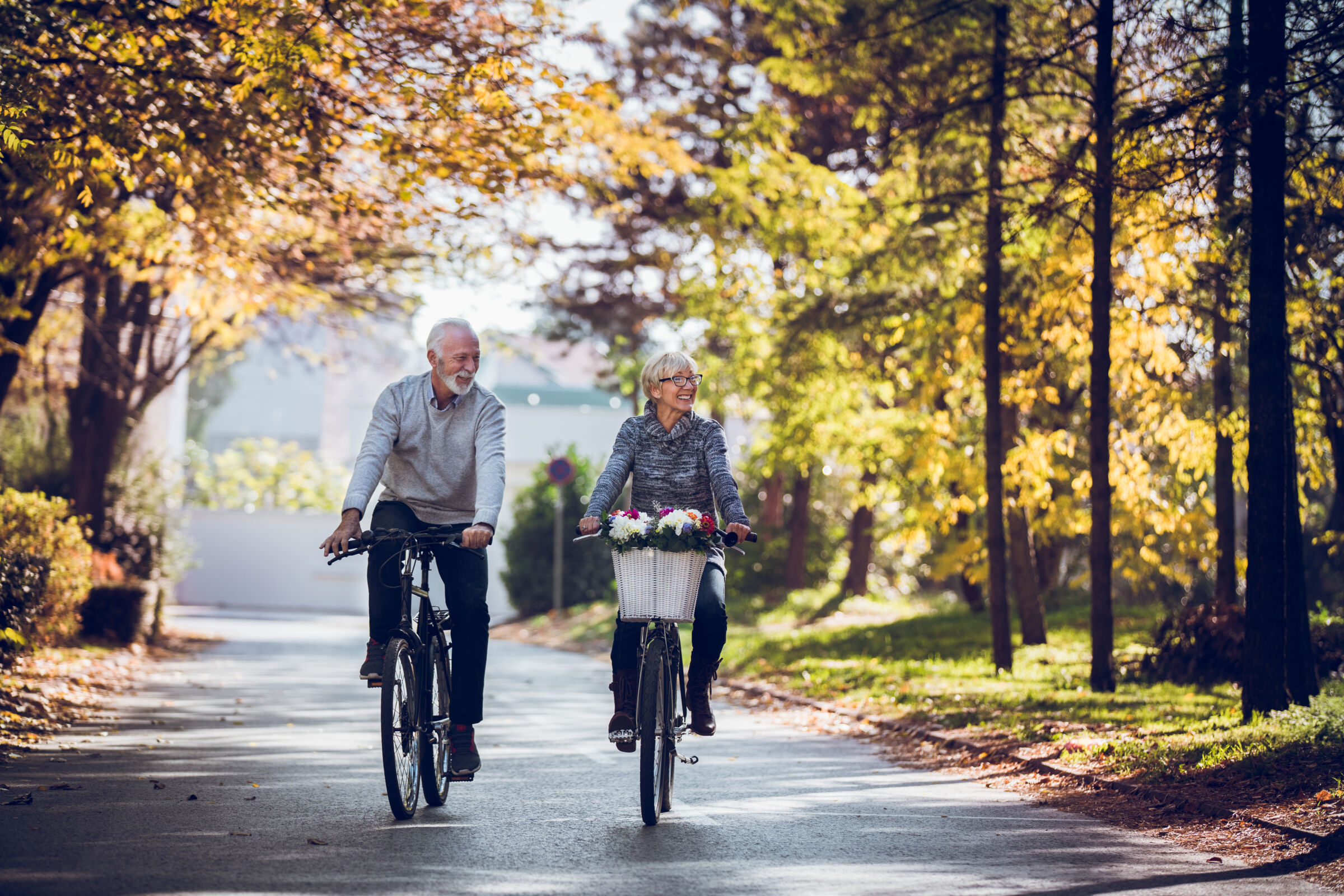 Senior couple biking through a park