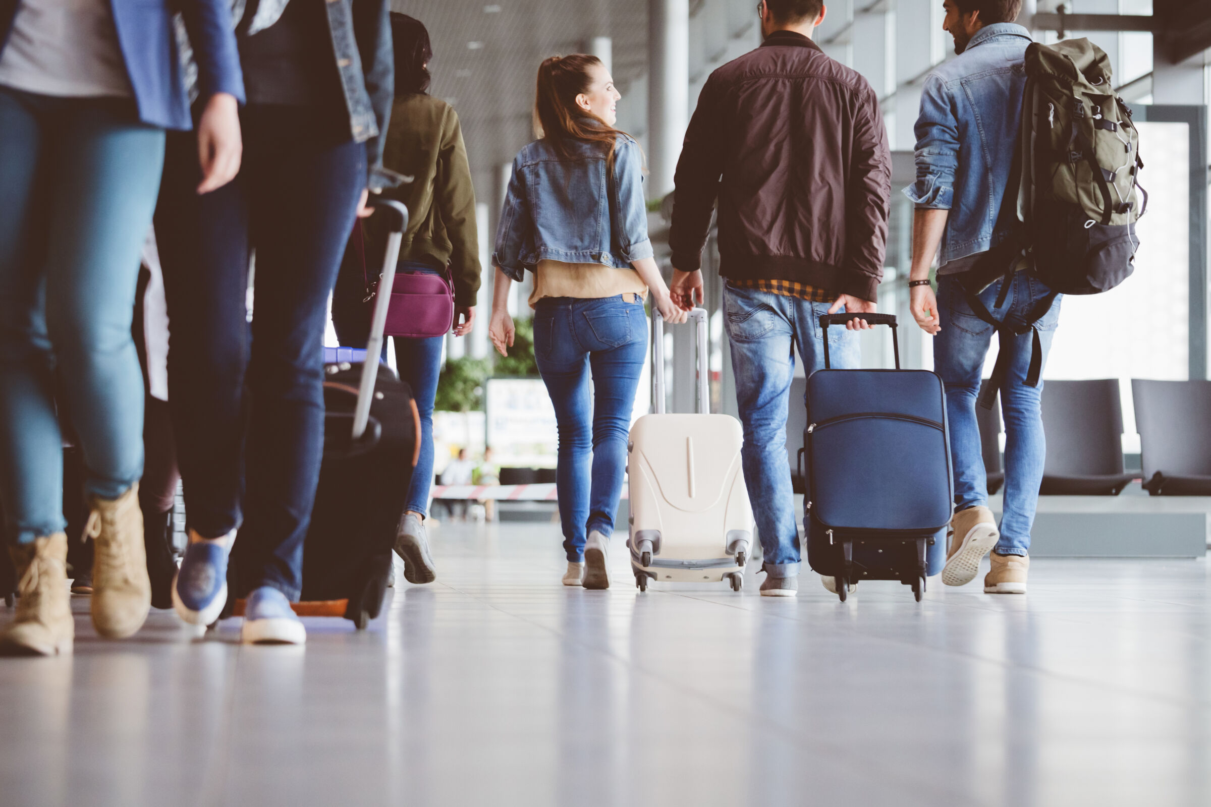 People walking with suitcases at an airport