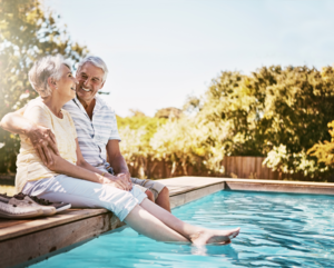 Senior couple sitting beside a pool