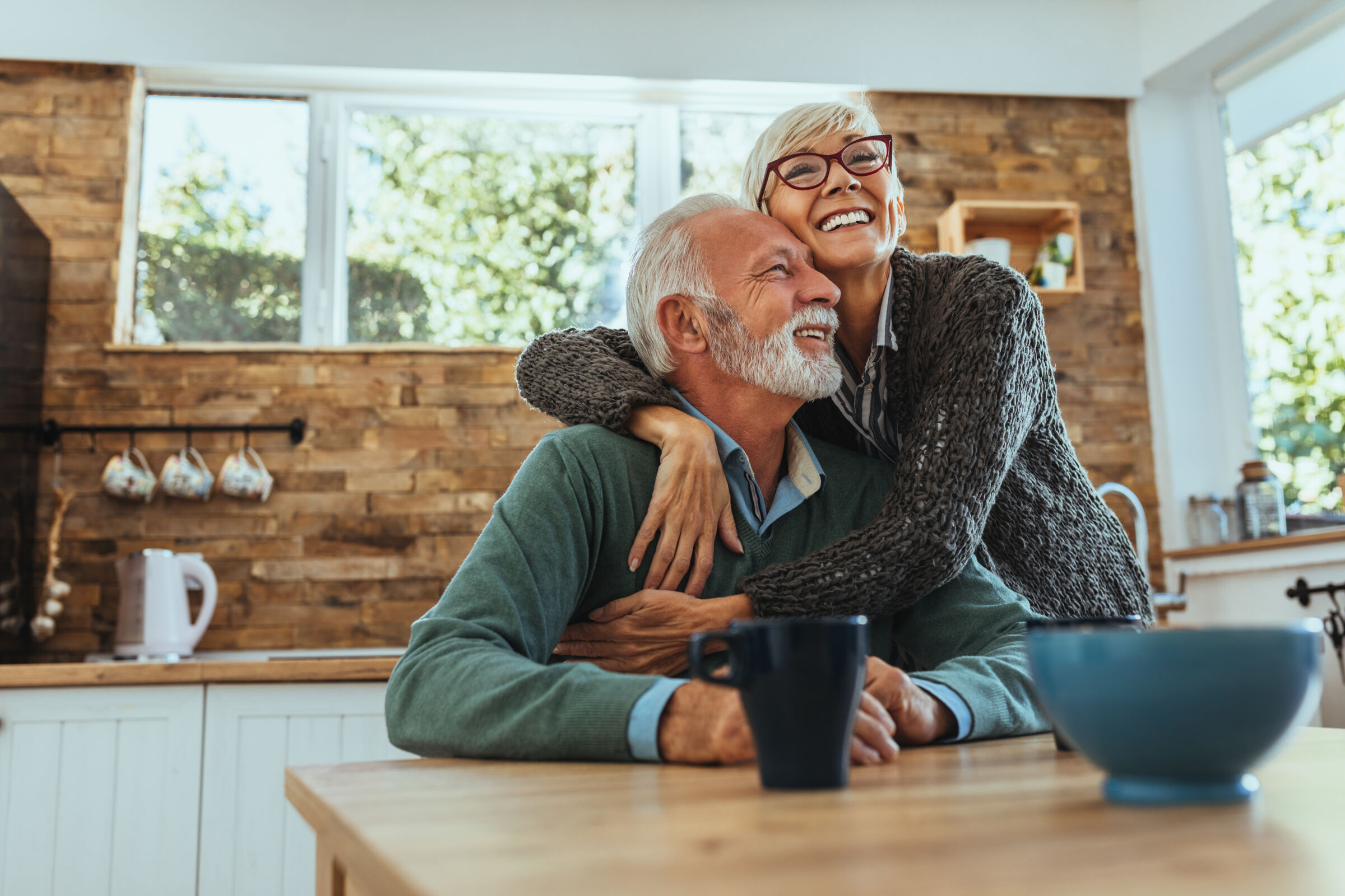 Senior couple hugging in the kitchen