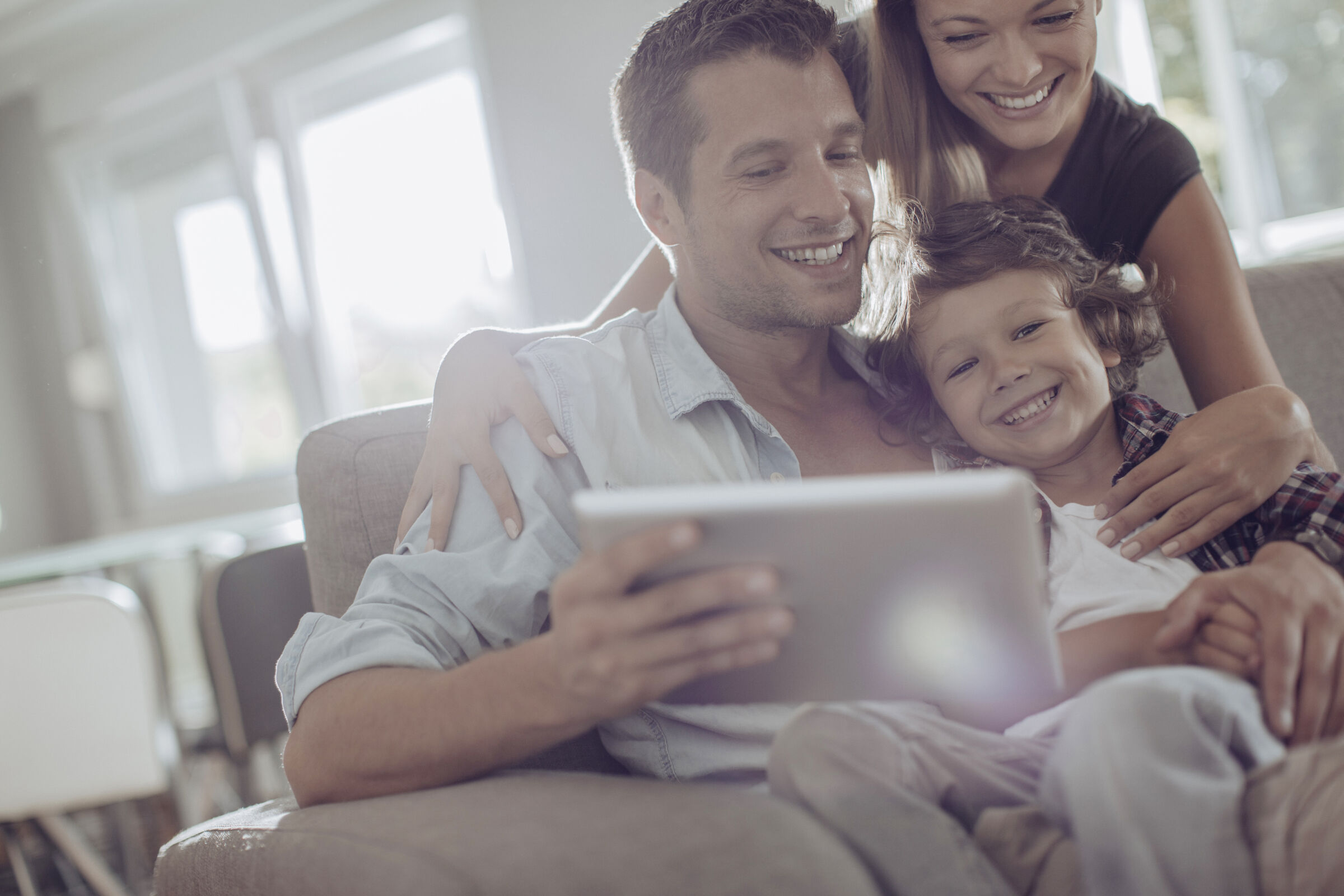 Family smiling at a tablet