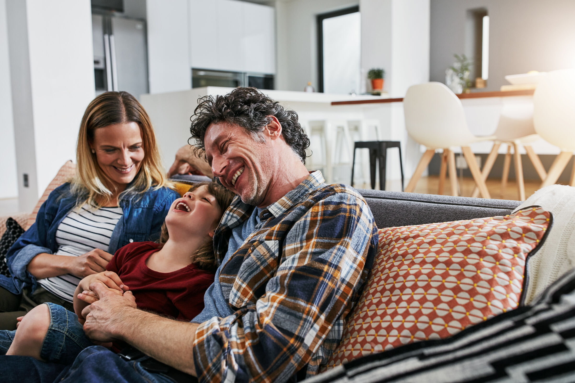 Family laughing on couch