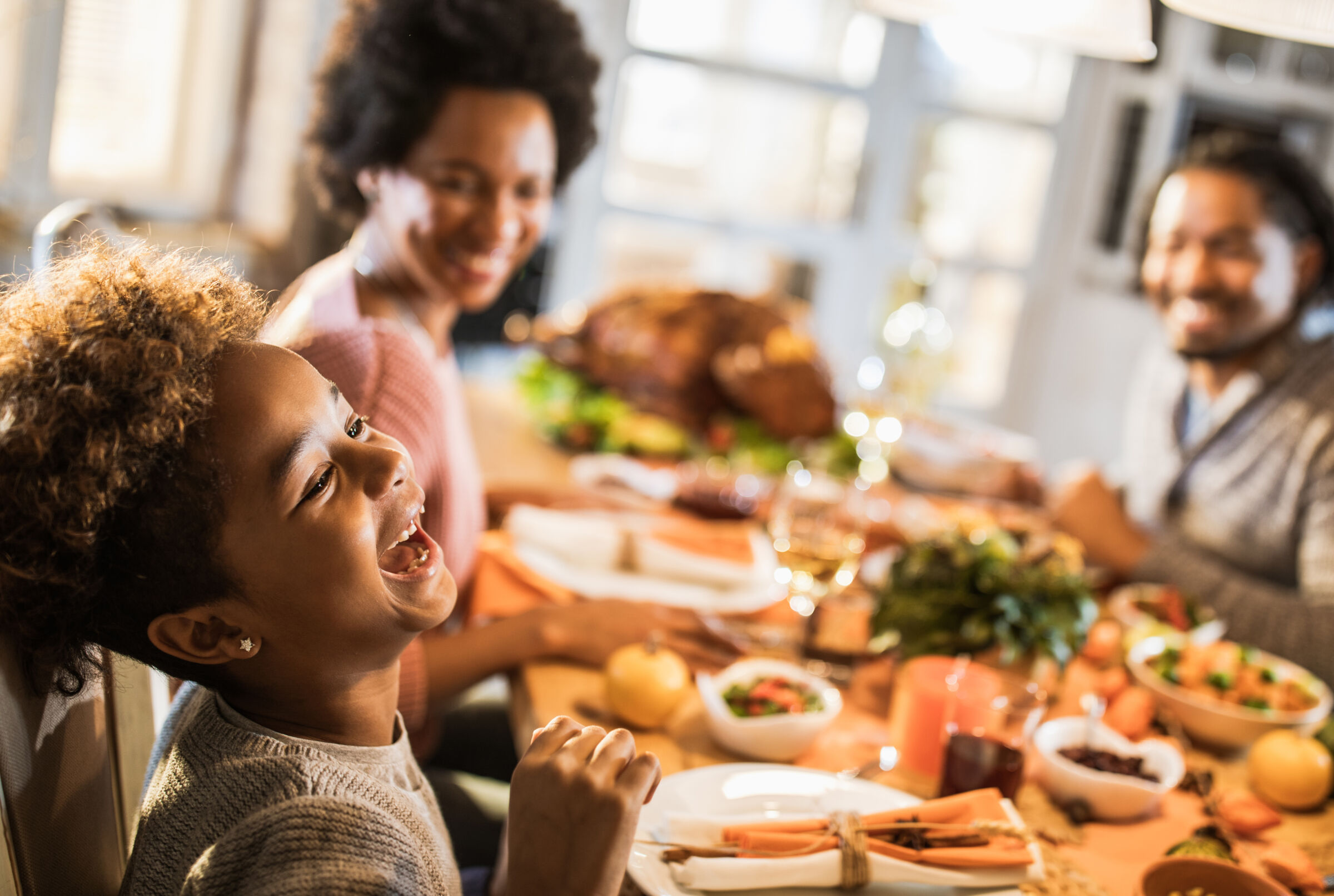 Family eating dinner, focus on laughing daughter