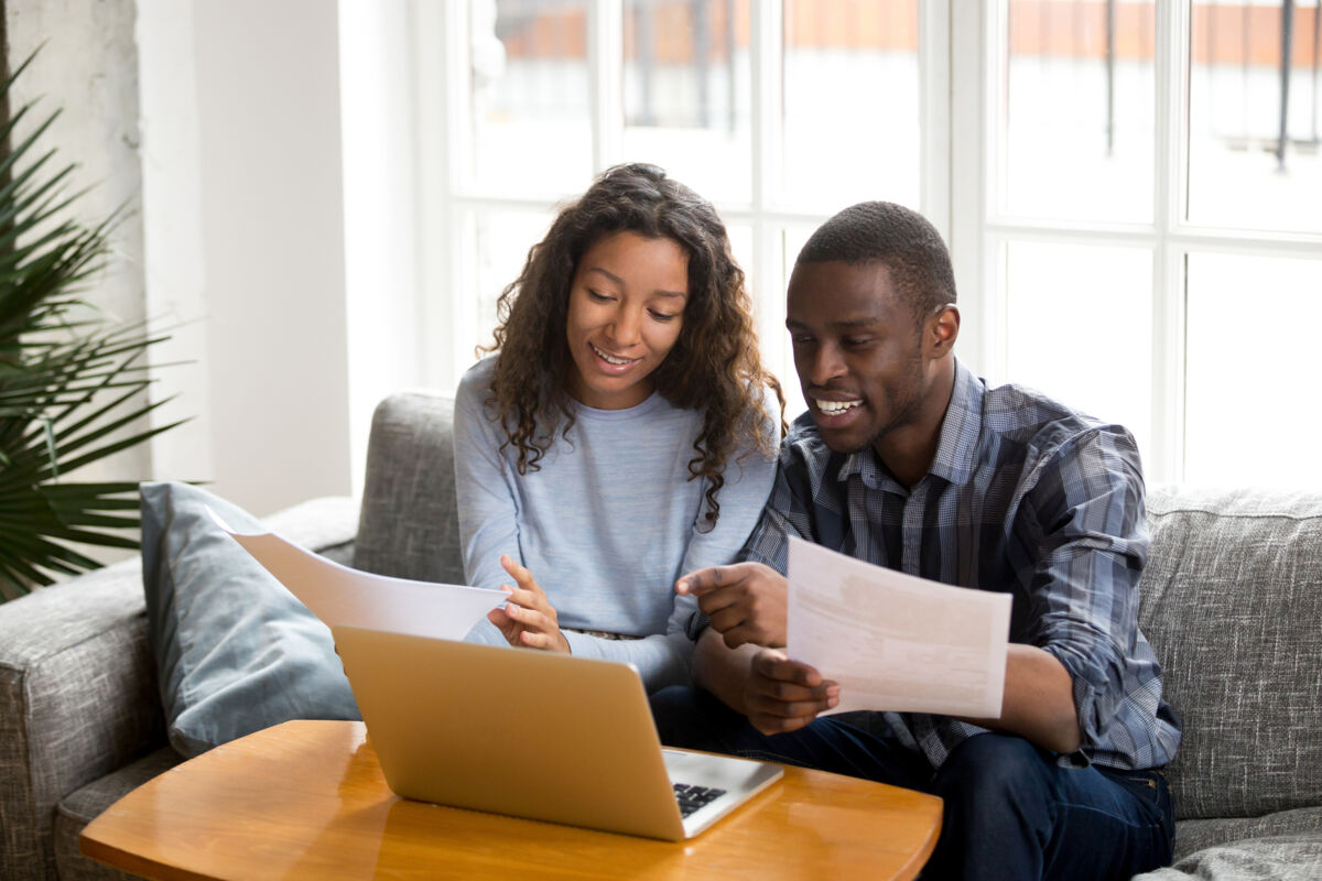 Couple with paperwork and a laptop