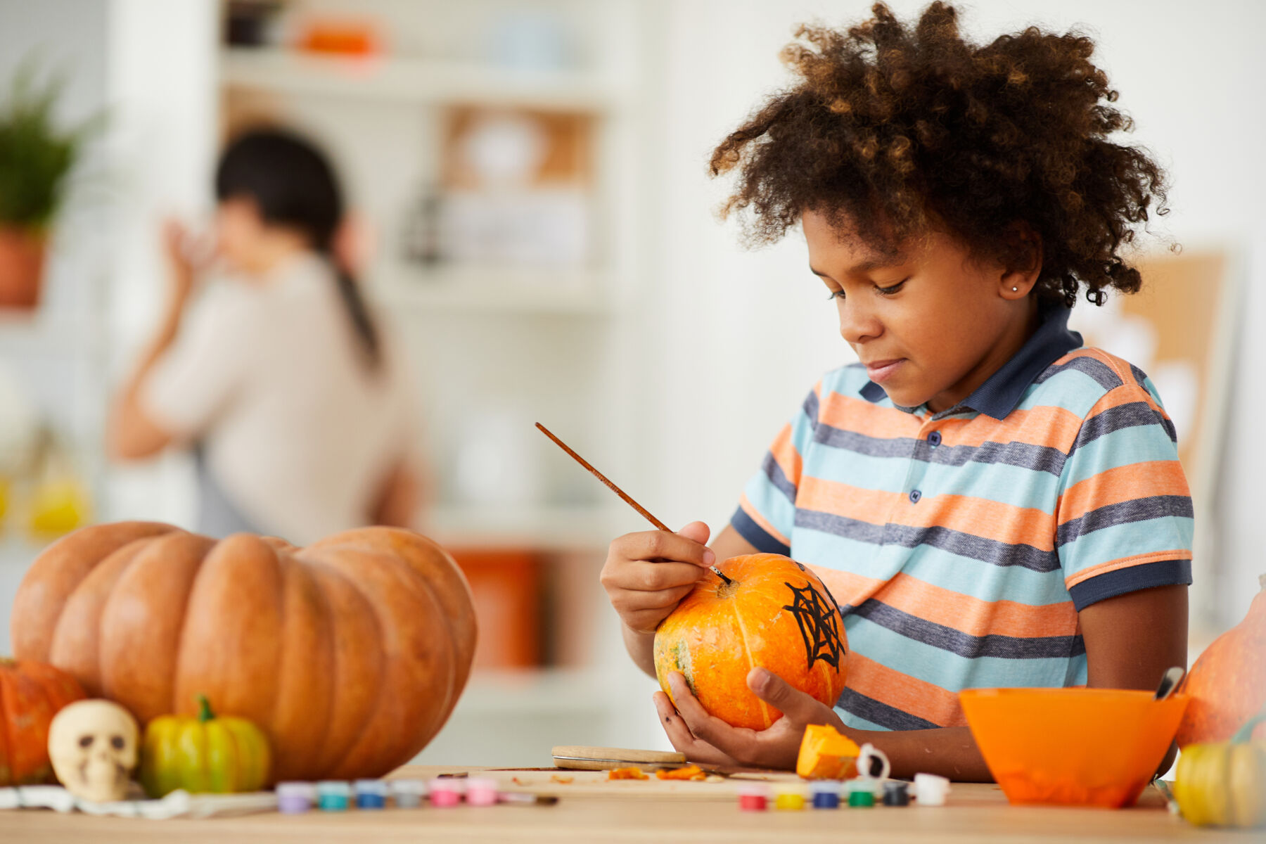 Child painting a pumpkin