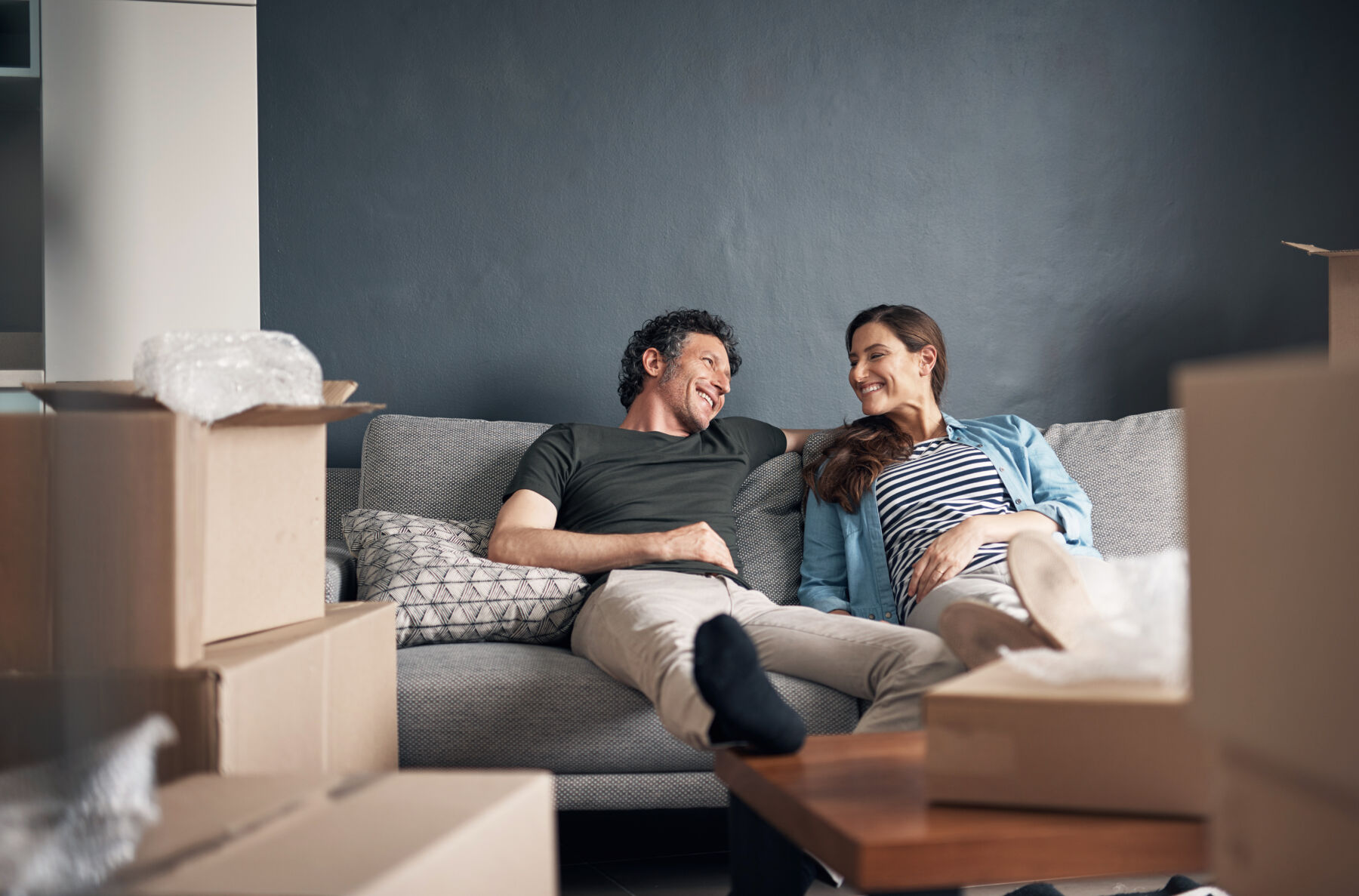 Couple relaxing on the couch with moving boxes