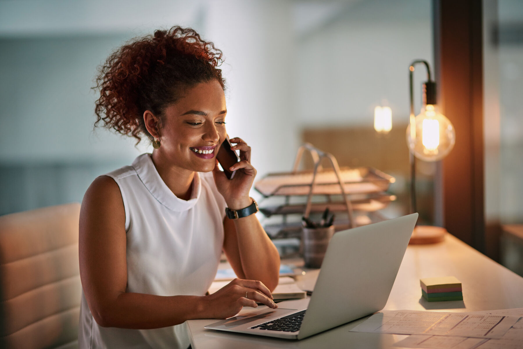 Woman smiling on the phone and working at home