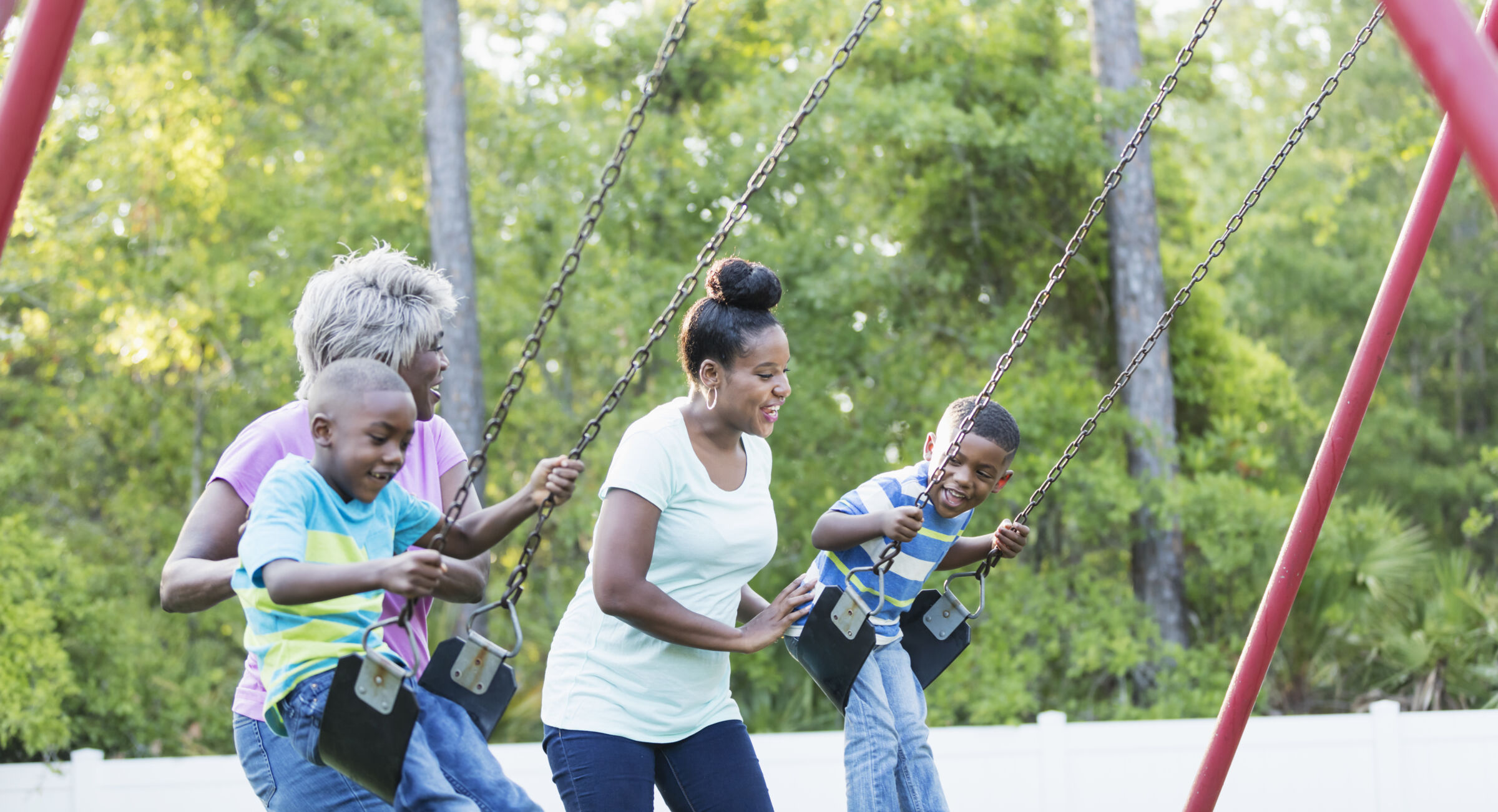 Multi-generational family playing on swings