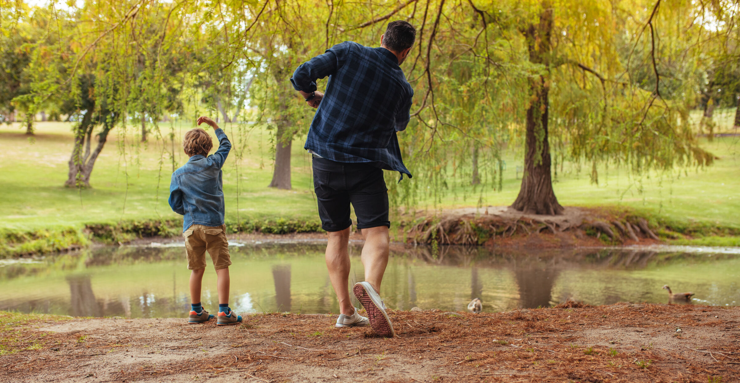 Father and son skipping rocks