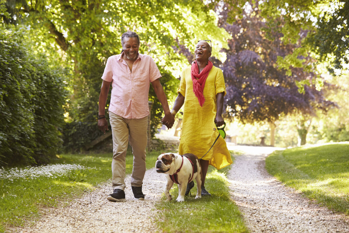 Couple walking their dog in a park