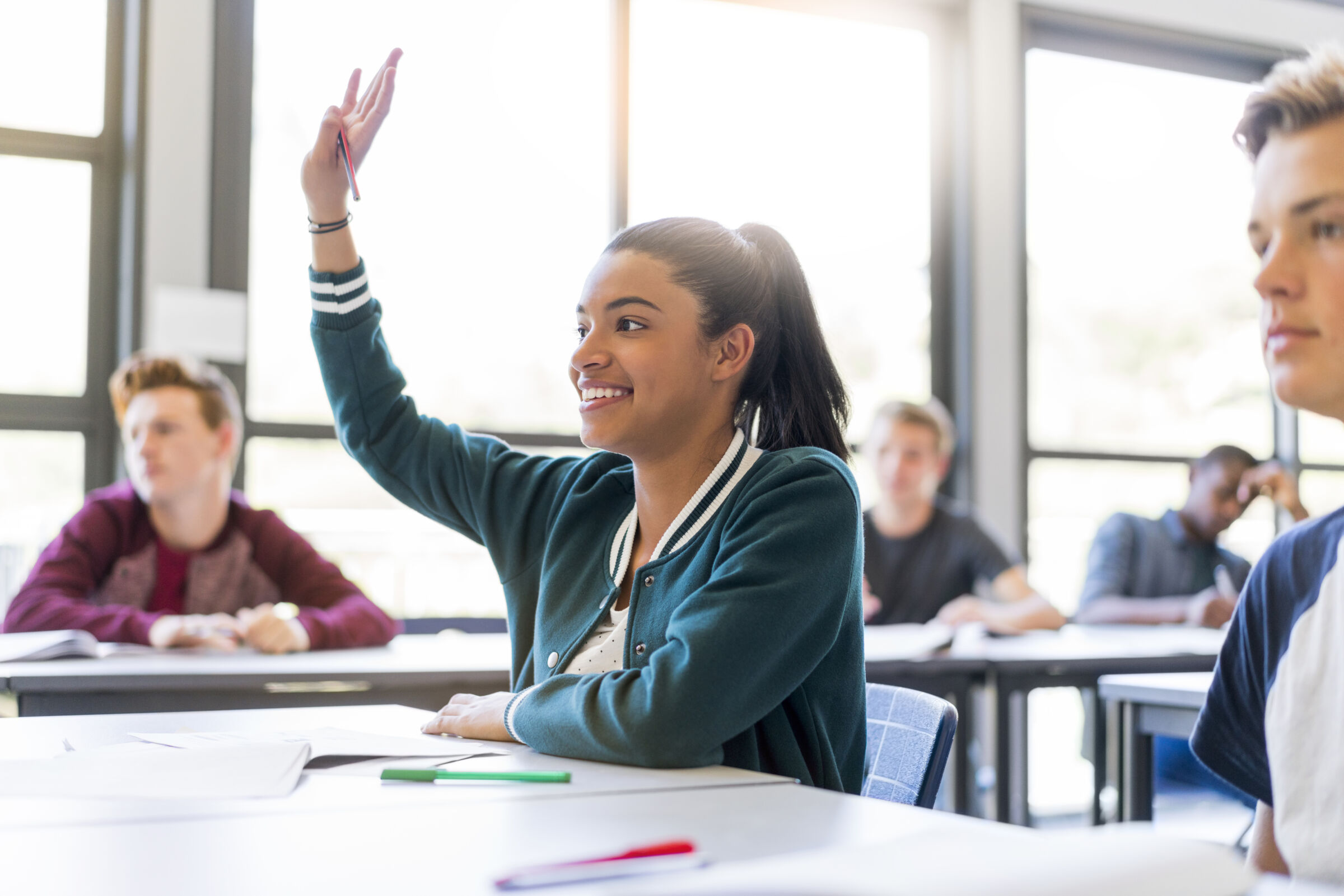 Student raising her hand in the classroom