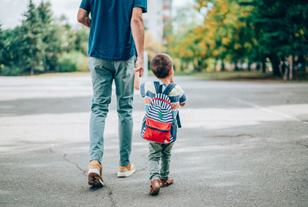 Little boy walking to school with his dad