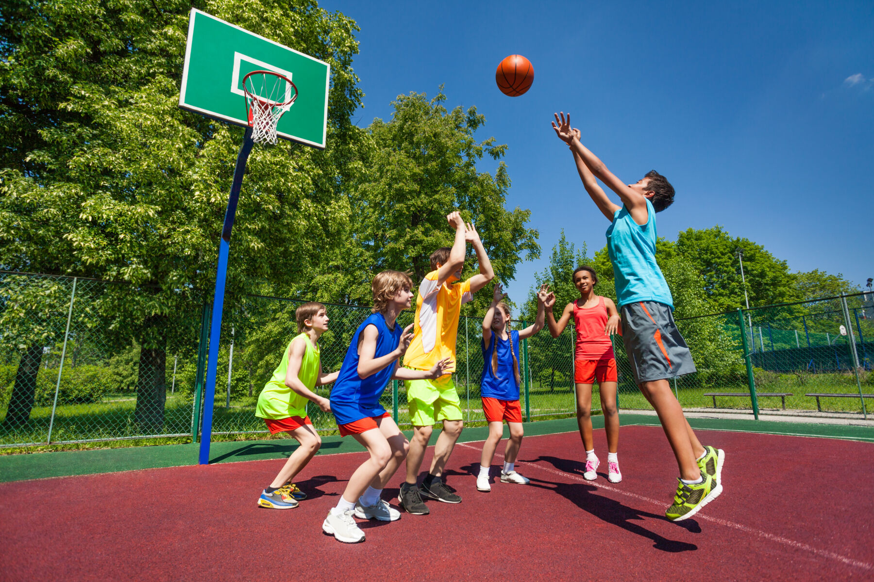 Group of kids playing basketball at a park