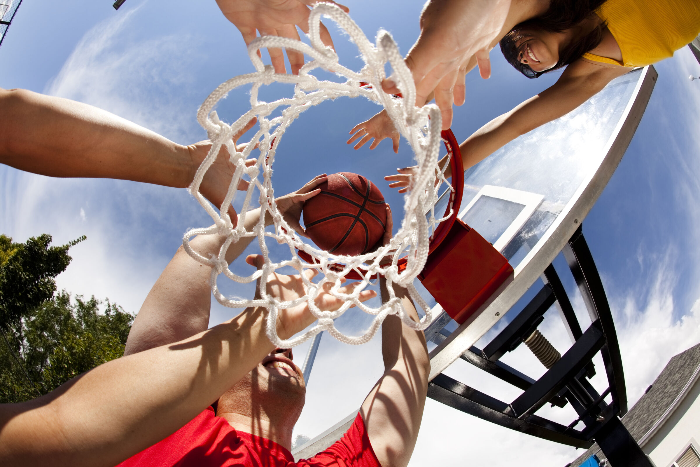 Up close picture of a basketball being dunked in a hoop