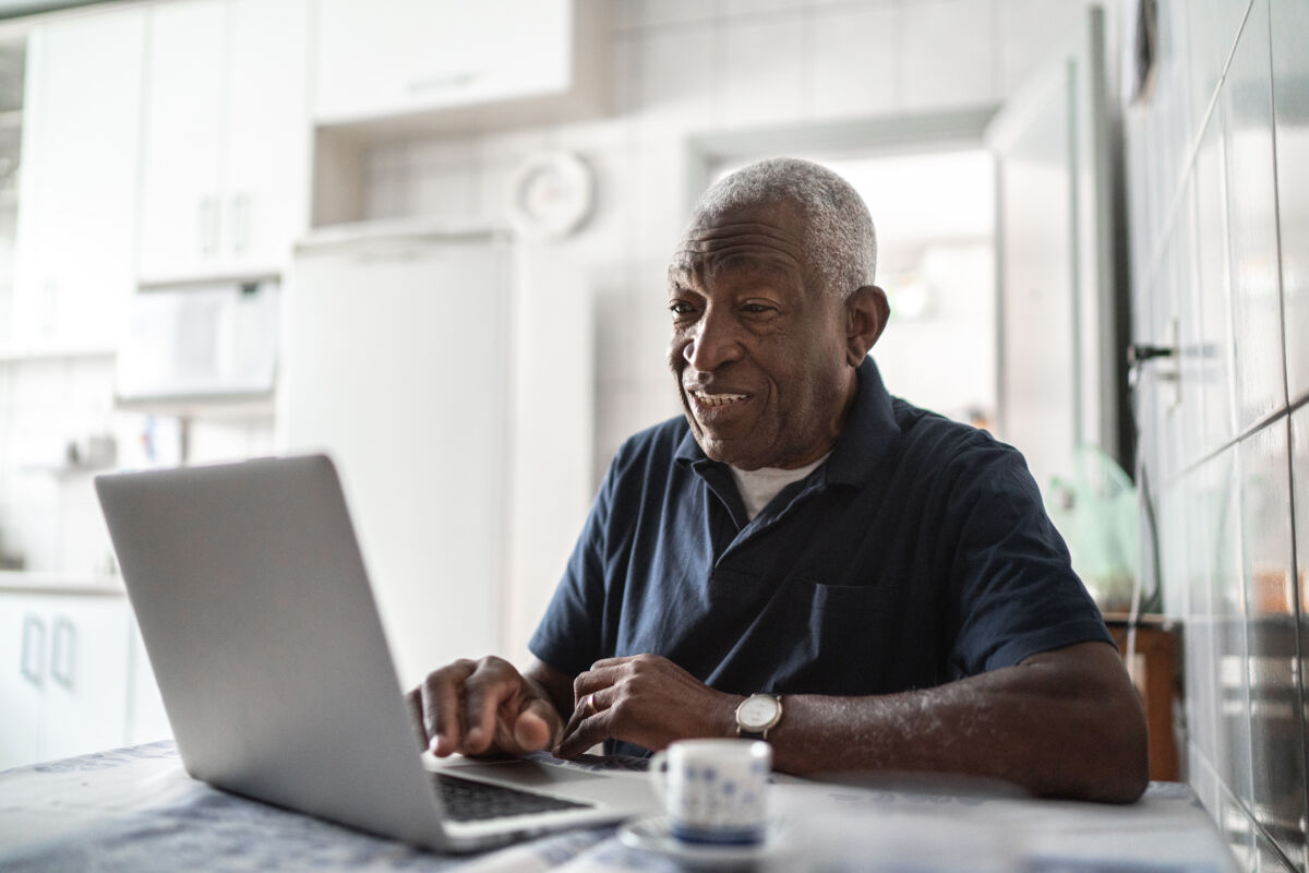 older man working on computer at home
