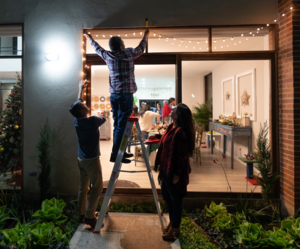 Family hanging Christmas lights