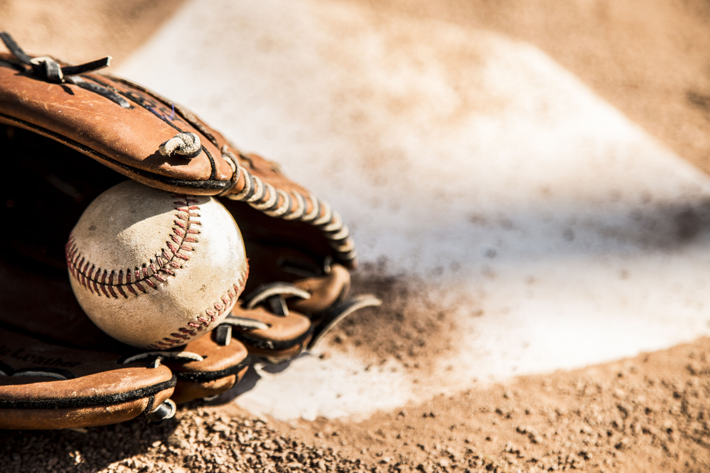 Closeup of a baseball glove holding a baseball.