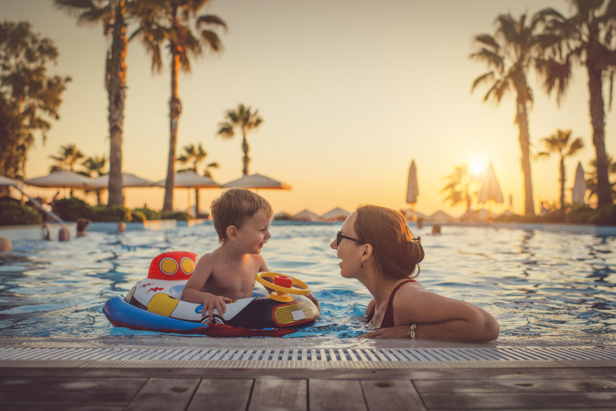 mom and son in pool at sunset