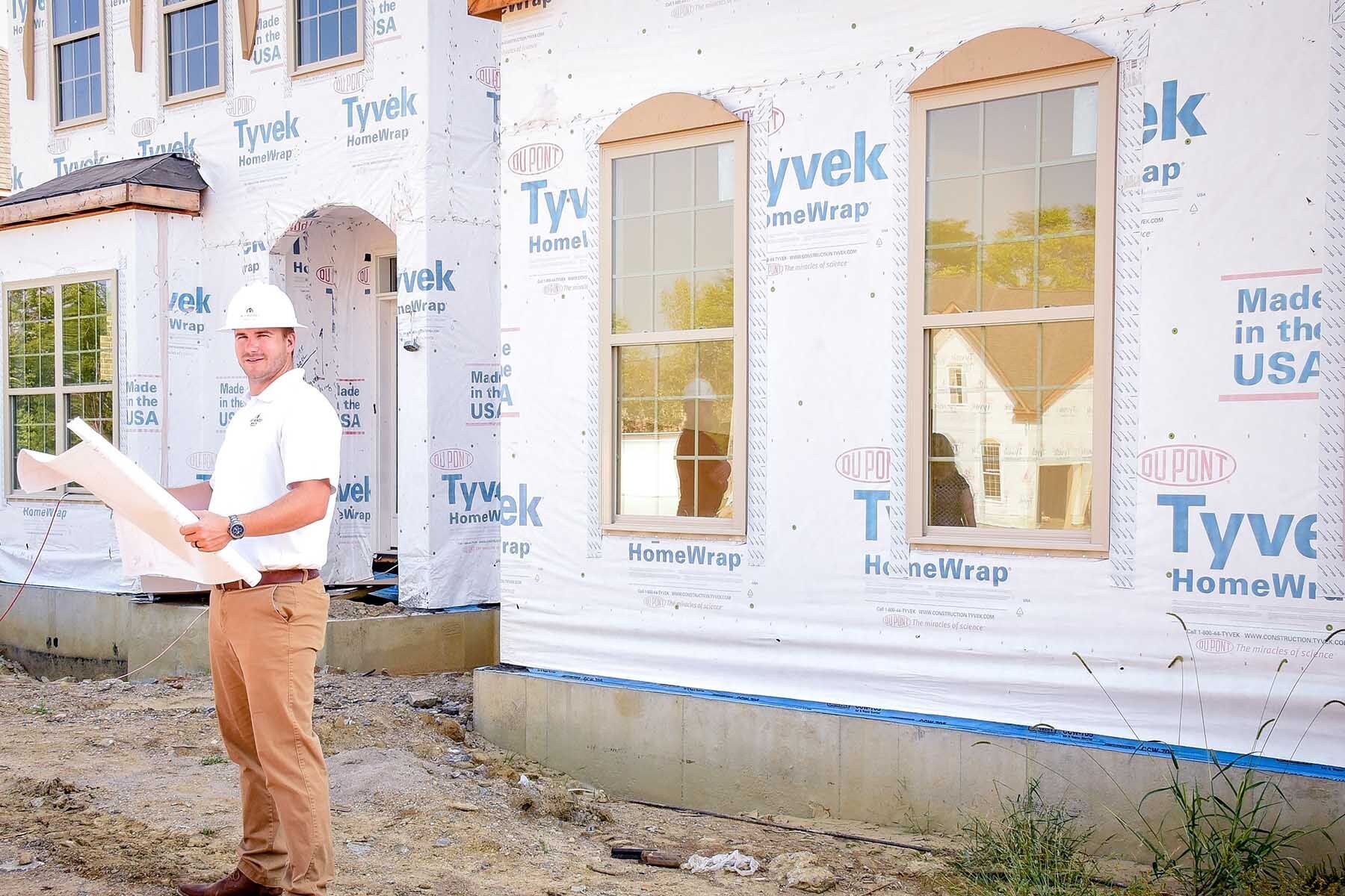 Construction Manager Standing Outside In-Progress Home