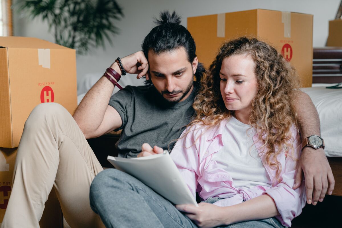 Home Buyers With Moving Boxes Making a List