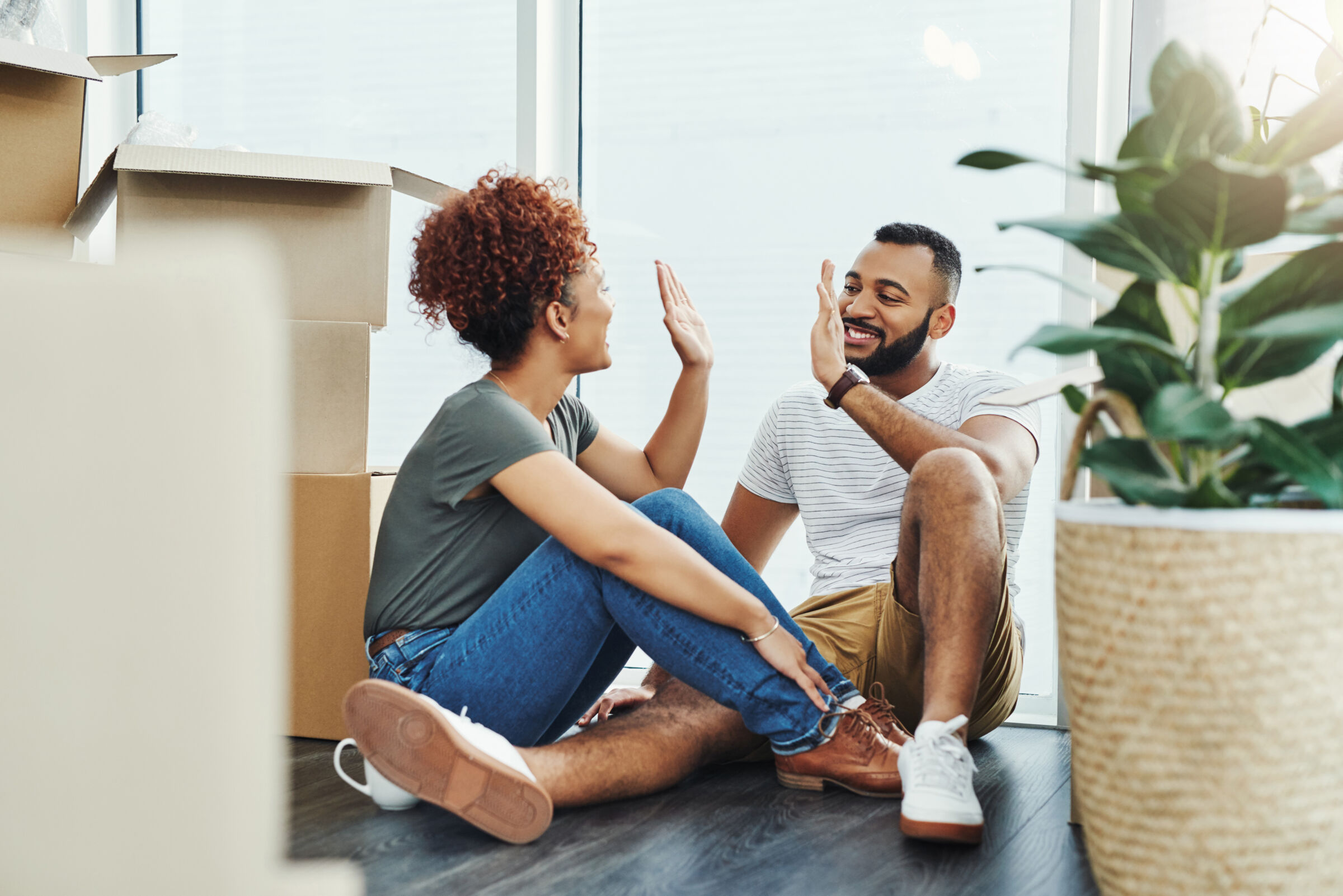 Couple High-Fiving With Moving Boxes