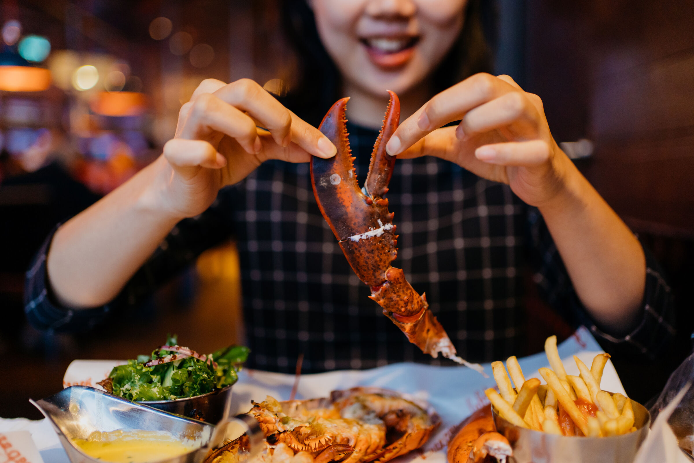 Woman Eating Lobster at Restaurant