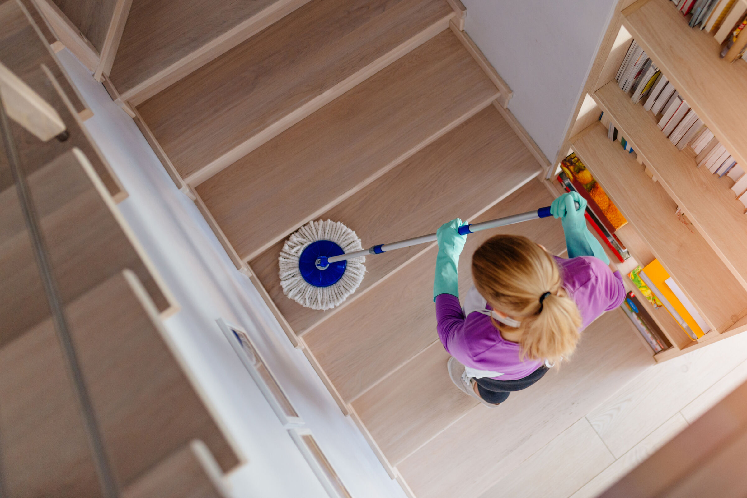 Woman mopping wood staircase