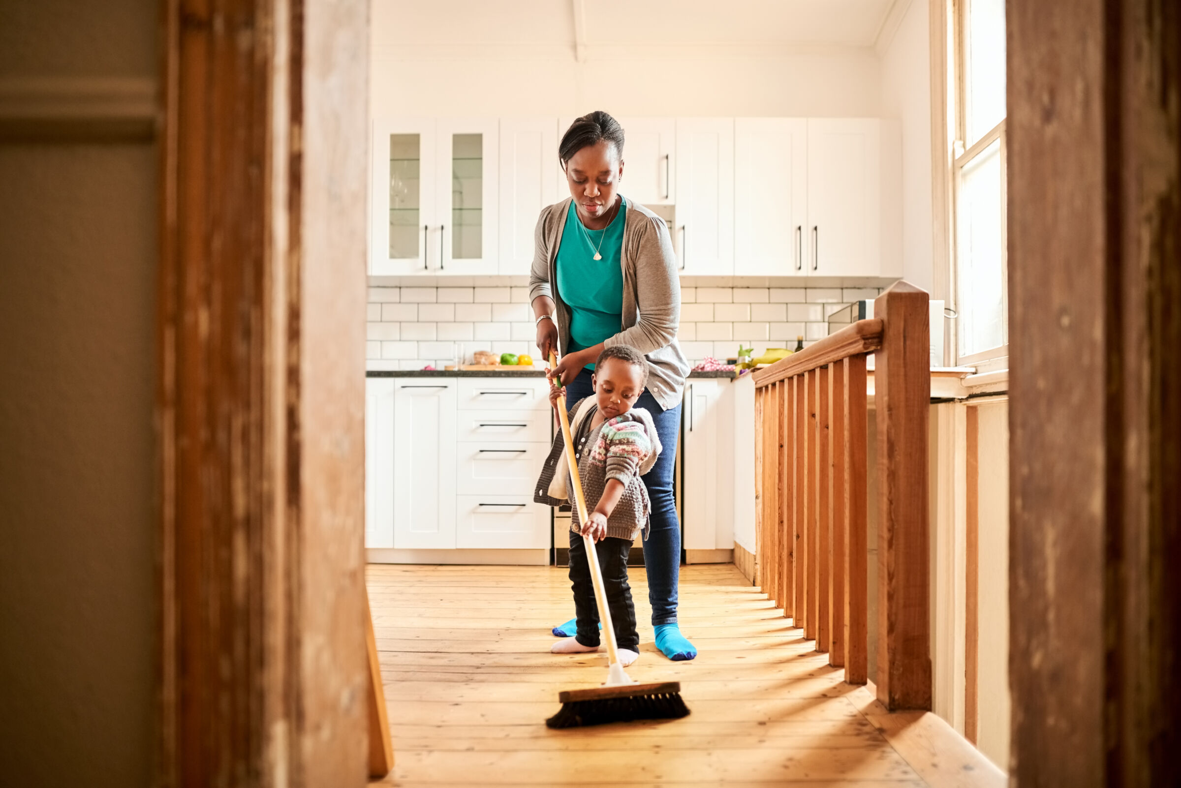 Mother and Child Sweeping in Home
