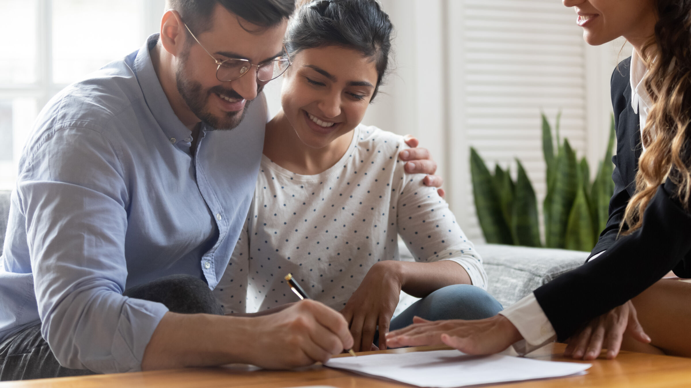 Couple Signing Closing Papers for New Home